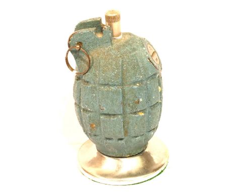British WWII INERT Mills grenade, later converted to a perpetual table lighter, raised on a circular stand, total H: 10 cm. P