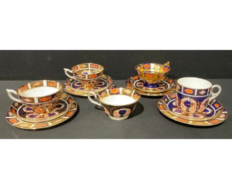 A Royal Crown Derby 1128 Imari pattern trio, c.1934; an associated pair of 1128 Imari trios; another associated trio, solid g