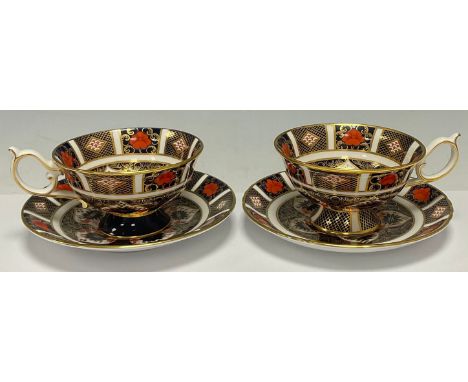 A pair of Royal Crown Derby Imari palette 1128 pattern pedestal teacups and saucers, second quality, printed marks 