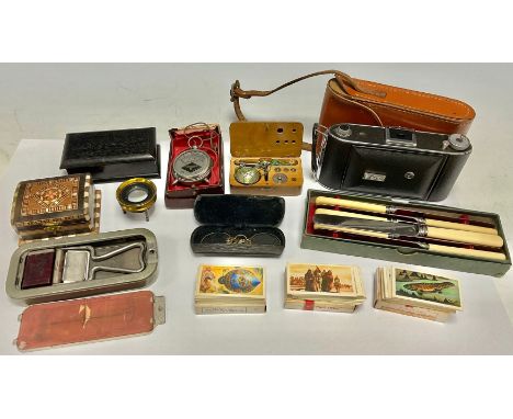 A set of pocket scales, wooden box; a pair of gold plated spectacles, cased; a brass magnifying lens; a camera; an ebonised b