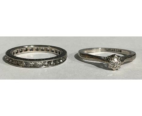 An 18ct white gold illusion set diamond solitaire ring, platinum bezel, size K, 2.2g; a sliver eternity ring, set with stones