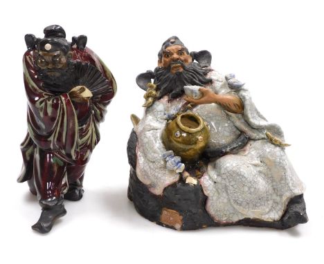 A 20thC Chinese mudman figure of Zhong Kui, modelled seated with a jar, and a bowl in his hand, the body with four bats, seal