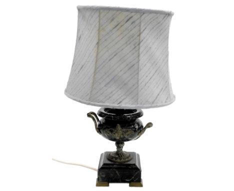 A serpentine and brass table lamp, of twin handled urn form, raised on a plinth base, on brass feet, with shade, 53.5cm high.