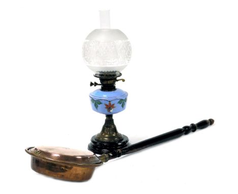An early 20thC brass oil lamp, with a blue glass reservoir, overpainted with fuchsias, on a black socle base, with chimney an