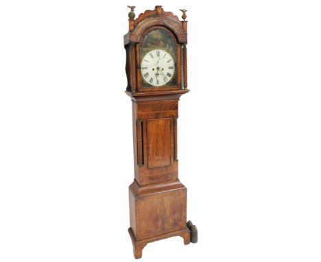 An early 19thC mahogany and rosewood longcase clock, the break arch dial painted with a pastoral scene, dial bearing Roman nu