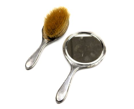 A George V silver backed hand mirror, together with a hairbrush, with engine turned decoration, initial engraved, Sheffield 1