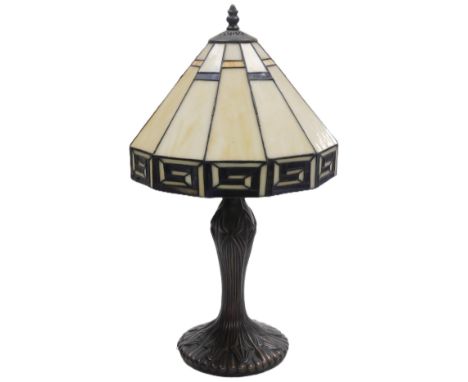 A Tiffany style table lamp, with a twelve sided opalescent shade, raised on a bronzed plaster base, 54cm high.