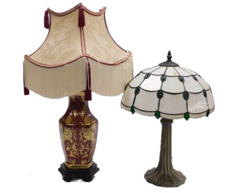A Tiffany style table lamp, with an eleven sided opalescent green jewelled shade, raised on a bronzed plaster base, 45cm high