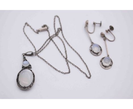 An early 20th century white metal (tests as silver) and moonstone necklace and earrings. The pierced design oval pendant is s