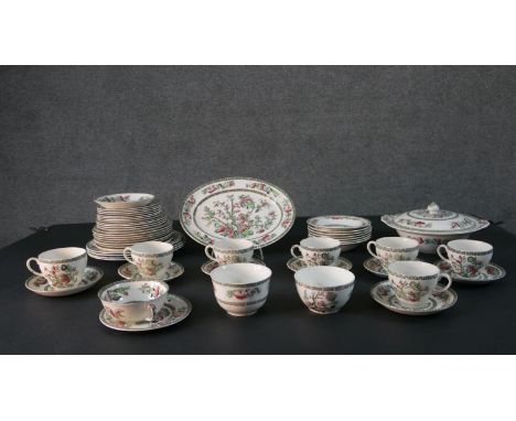 A Johnson Brothers Indian Tree pattern eight person part dinner service. Includes seven tea cups and saucers, a large oval pl