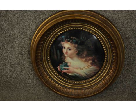 A round gilt framed ceramic plaque of a fairy. Makers mark verso. Dia.29cm. 