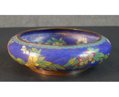 A Meji period Japanese cloisonné enamel flower design on blue ground bowl. Cloud design to the base. H.9 Diam.29cm 