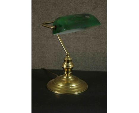 An early 20th century brass banker's desk lamp with green glass adjustable shade and on stepped circular base. H.38 W.27 D.18