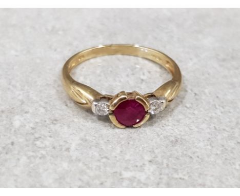 Ladies 9ct yellow gold ruby + diamond 3 stone ring, comprising of a round ruby set in the centre with a round brilliant cut d