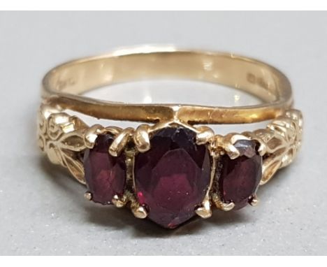 A 9ct yellow gold and garnet three stone ring, size P 3.63g gross.