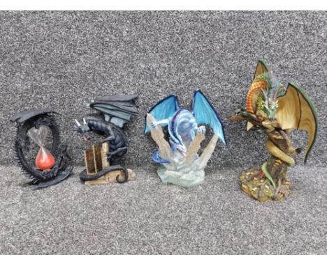 Three Land of the Dragons resin sculptures together with a sand timer with dragon decoration.