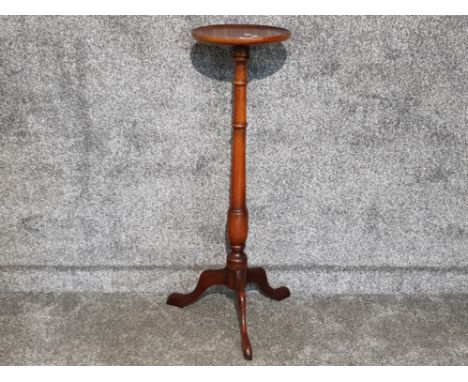 A reproduction mahogany circular plant stand raised on tripod legs 98.5cm high.