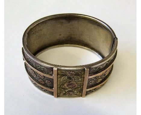 White Metal Yellow Metal Mounted Wide Hinged Bangle, 1 side plain, the other decorated with central gilt panel flowers &amp; 