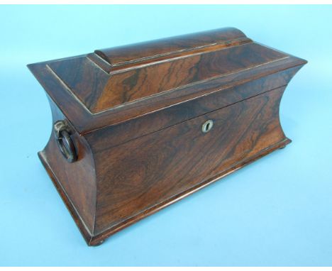 An early-19th century rosewood sarcophagus-shaped tea caddy with wood ring handles, fitted with two canisters and mixing bowl