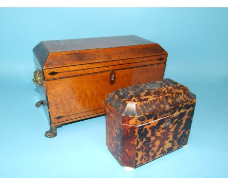 A bird's-eye maple tea caddy of sarcophagus shape, fitted with two canisters and mixing bowl aperture, raised on brass paw fe