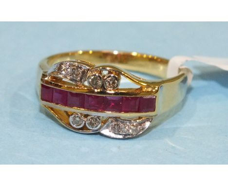 A ruby and diamond cross-over ring channel set a row of seven square cut rubies with diamond points above and below, the moun