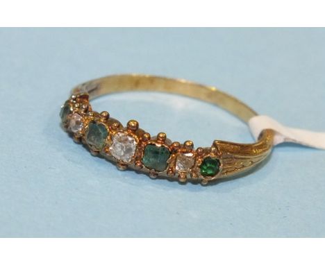 An early 19th century emerald and diamond half hoop ring set four graduated foiled emeralds and three diamonds in closed back