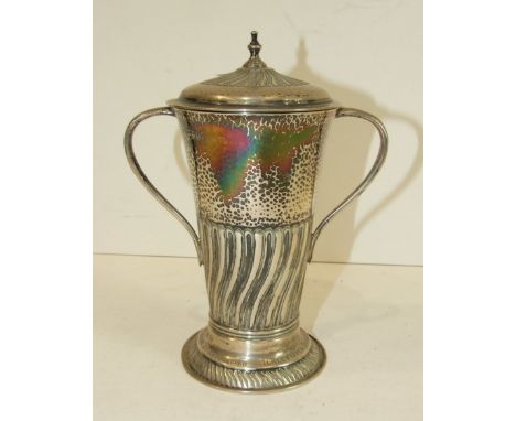 A beaten silver two-handled cup and cover by Henry Stratford, the tapered half-writhen reeded body on spreading circular base