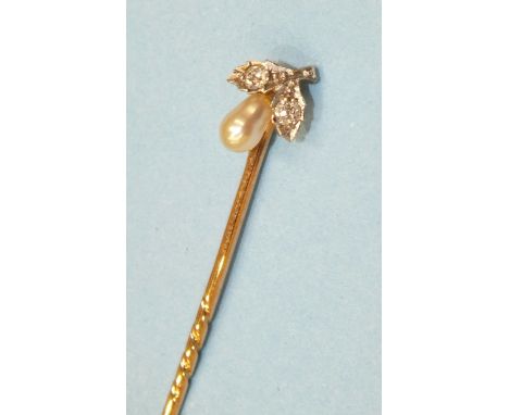 A Victorian gold stick pin, the terminal set with baroque pearl below two old brilliant cut diamond set leaves, 54mm, 1.4g.