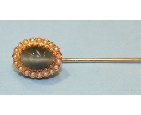 A French 18ct gold stick pin set chrysoberyl cats eye within a seed pearl border, 2.5g in Tiffany & Co case.