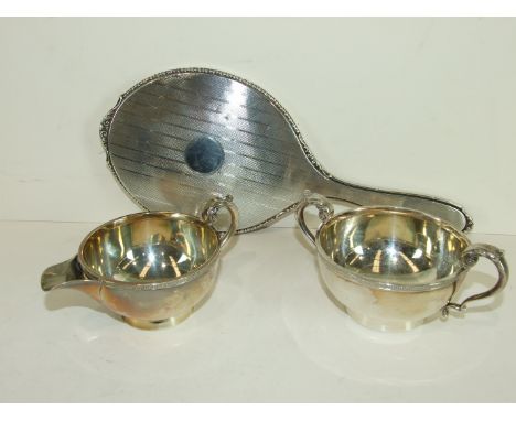 A silver two-handled sugar bowl, a matching cream jug, Birmingham 1924, 5.5cm high, ___6½oz and a silver-backed engine-turned