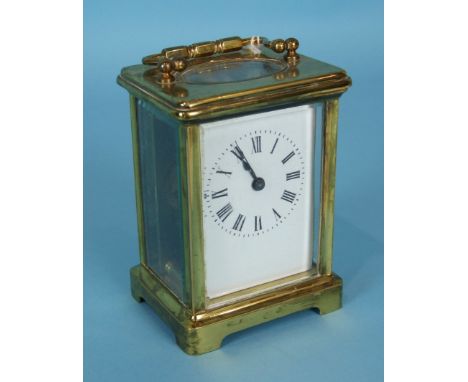 A French brass carriage timepiece, the plain lacquered case with white enamel dial, the mount with Swiss escapement, 15cm hig