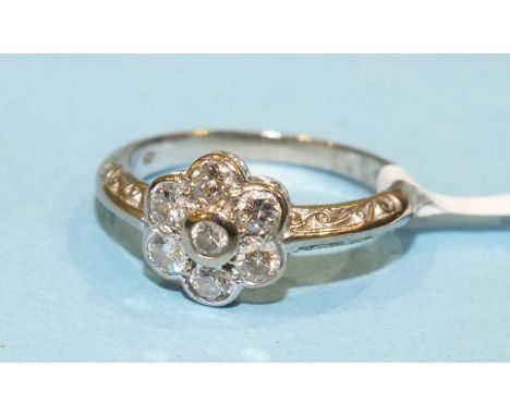 A diamond daisy-cluster ring, collet set seven brilliant cut diamonds in 18ct white gold mount with engraved shoulders, size 