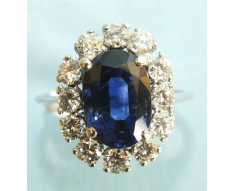 A sapphire and diamond cluster ring, the oval sapphire of approximately 4cts claw set within a border of twelve brilliant cut