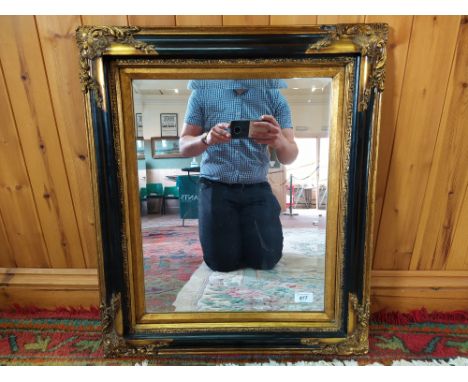 A gilded and black finish Empire style bevelled mirror, frame 26" x 23"