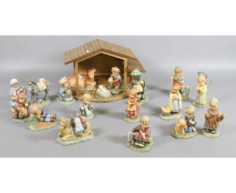 An eighteen piece bisque Goebel nativity set with certificates and a wooden stable.
