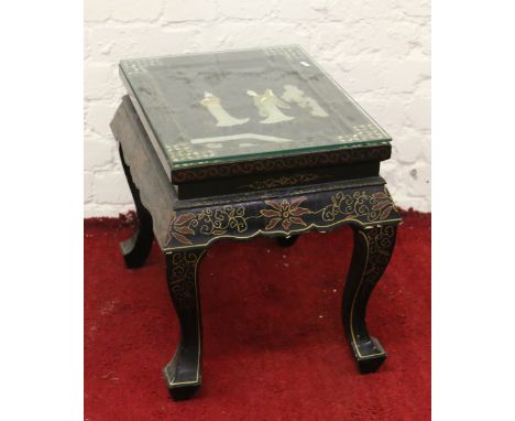 An oriental painted occasional table set with mother of pearl and oriental figures.