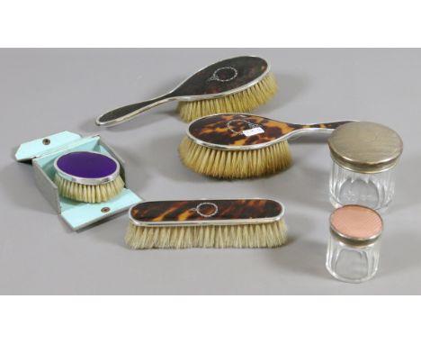 Three silver mounted and tortoiseshell clothes brushes along with two silver tipped hat pin jars and a boxed silver mounted a