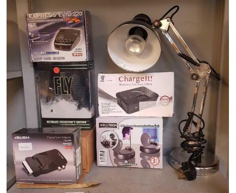 Shelf of boxed items, speed/laser detector, wireless transmission set battery charger, angle poise lamp, brass desk lamp etc