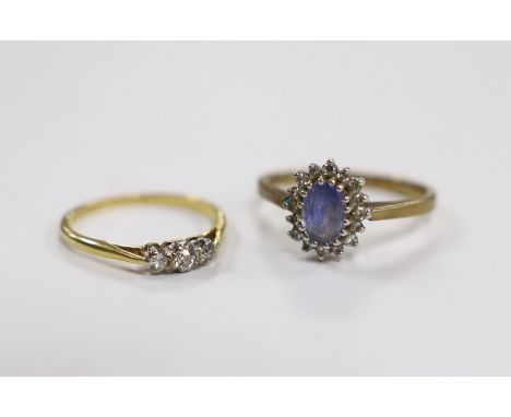 An 18ct, plat and three stone diamond chip set ring, size M and a modern 9ct gold, sapphire and diamond set oval cluster ring