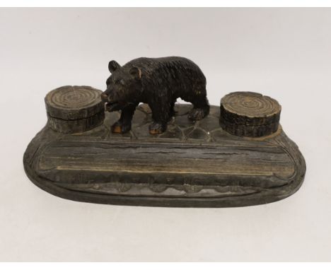 A Black Forest carved wooden inkstand, with ceramic inserts to the inkwells, 31cm wide