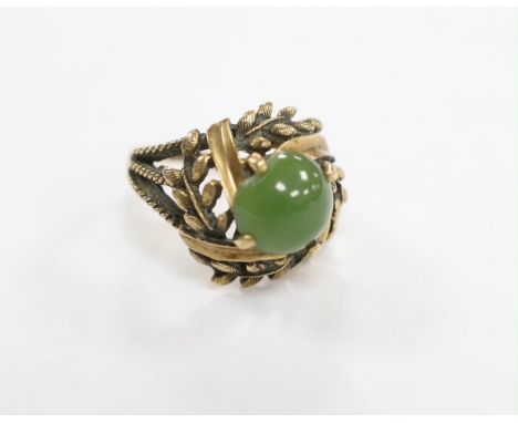A 10k and oval cabochon jade set dress ring, size L, gross weight 6.2 grams.
