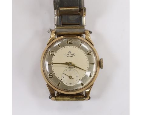 A gentleman's 9ct gold Smiths Deluxe manual wind wrist watch, with subsidiary seconds and case back inscription, on an associ