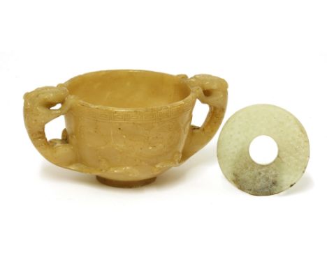 A Chinese soapstone two-handled cup,Ming dynasty (1368-1644), of circular form on a circular foot, the sides carved with chil