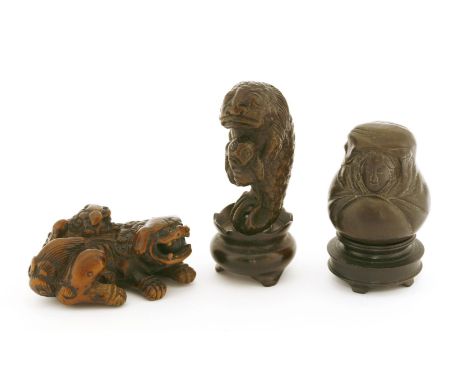 A Japanese wooden netsuke, of a Buddhist lion carrying a pup on her back, 5.5cm long, a wood netsuke, of a girl, 4cm high, as