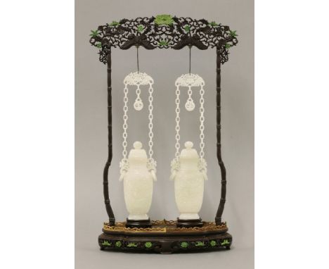 A pair of Chinese jade vases and covers,19th/20th century, each of baluster form carved with a shou roundel amongst scrolling
