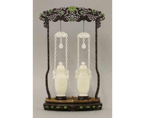 A pair of Chinese jade vases and covers,19th/20th century, each of baluster form carved with a shou roundel amongst scrolling