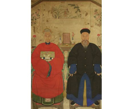 A large Chinese ancestor portrait painting,early 20th century, of an elderly couple seated on armchairs in front of a table w