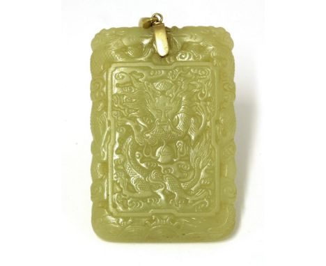 A Chinese yellow jade plaque,Qing dynasty (1644-1911), of rectangular form, one side carved with a dragon chasing a flaming p