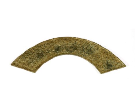 A Chinese jade pendant, huang,possibly Han dynasty (206 BC - AD 220), of arc shape, carved with archaic swirl-shaped studs,20