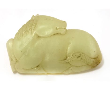 A Chinese jade belt hook,late Ming/early Qing dynasty, in the shape of a recumbent horse, its head turned back, the stone of 